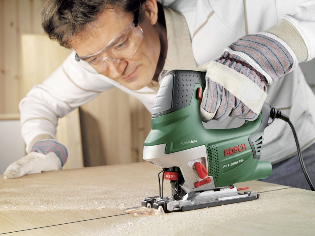 Carpintero serrando madera con una sierra de calar Bosch pst 1000 pel